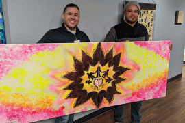 Artist Johnny Felix (right) and Omar Ramos, Waterford Place program development and operations manager, hold the painting Felix created to honor people dealing with cancer.