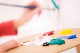 person painting, holding paint palette