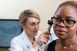 An audiologist conducts an ear exam