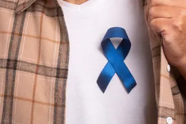 Young man wearing colorectal cancer awareness ribbon
