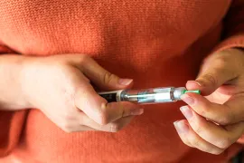 Woman holding GLP-1 injector