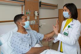 RUSH physician assesses RUSH patient sitting upright in hospital bed