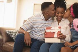 Father and daughter kissing mother on cheek