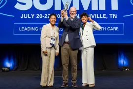 award recipients standing on stage in front of a blue background