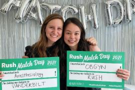 Two students holding Rush Match Day posters