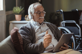 Senior Man Sitting on Living Room On Tablet
