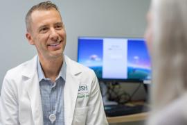 Augusto Miravalle, MD, meets with a patient.