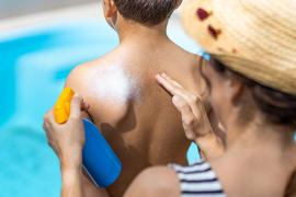 Woman applying sunscreen on child