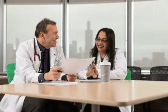 Dr. Celalettin Ustan and Dr. Sunita Nathan sitting at a table talking