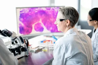 Lab tech looking at microscope