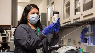 A clinician inspects a medication container