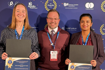 Rush's environmental sustainability team posing in front of a step-and-repeat holding awards.