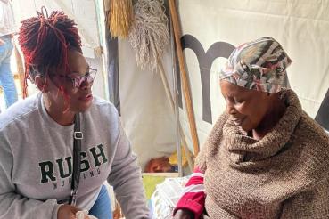 Aisha Ealey, DNP, APRN, cares for women and babies across the world. She is wearing a gray Rush University College of Nursing crewneck.