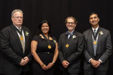 Standing, left to right, in front of a black background, are Robert J. McCarthy, Rupa Sanghani, Jason S. Turner and Pete S. Batra.