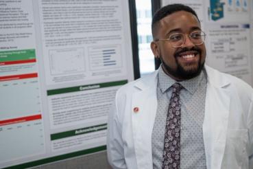 College of Nursing student smiles in front of their capstone presentation
