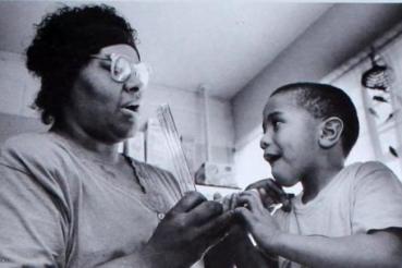 Dorie Burrell teaches young child how to use a device that measures lung capacity in 1994.