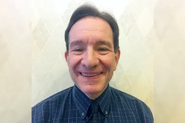 Head shot of David Margolin wearing a blue shirt and tie