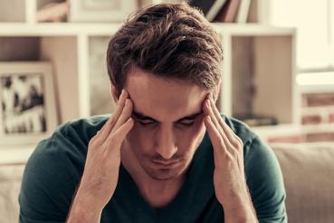 Man with headache holding head