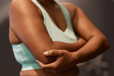 Woman in light green tank with arms crossed