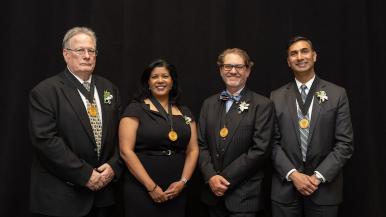 Standing, left to right, in front of a black background, are Robert J. McCarthy, Rupa Sanghani, Jason S. Turner and Pete S. Batra.