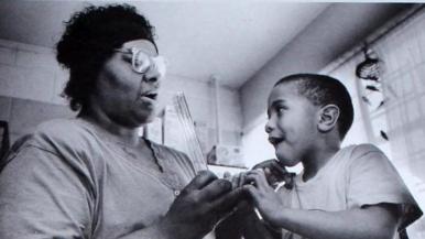 Dorie Burrell teaches young child how to use a device that measures lung capacity in 1994.