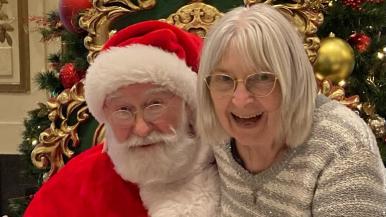 Lynn Stewart smiles alongside Santa Claus