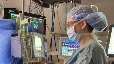 A nurse anesthetist monitors equipment during surgery