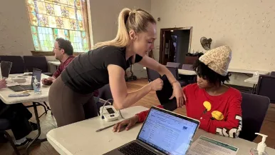 A student takes a woman's blood pressure