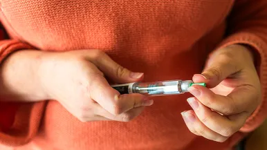 Woman holding GLP-1 injector