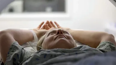 A patient lies back as she gets a heart CT scan.