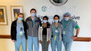 A group of health care providers wearing scrubs and masks at the Rush Pediatric Intensive Care Unit