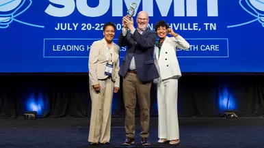 award recipients standing on stage in front of a blue background