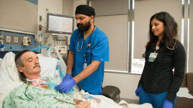 Two respiratory therapists at a patient's bedside