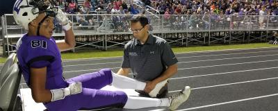 Dr. Patel treats player during high school football game