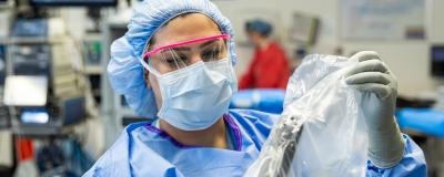 An OR nurse prepares a surgical machine