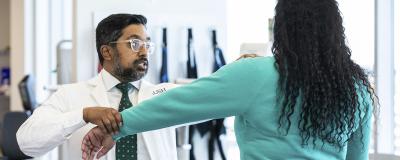 A doctor checks the arm of a patient.