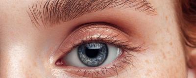 Close-up view of a person's eye, showing detailed features including the iris, eyelashes, and eyebrows.
