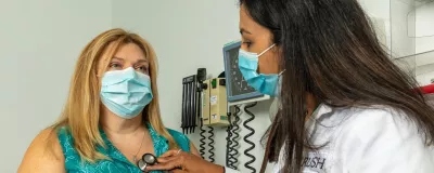 Rao, MD listening to a cardiovascular patients heart.