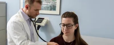 Rush physician checking a patient's heart with a stethoscope