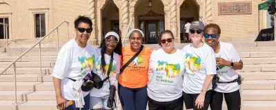 Six people wearing event t-shirts standing together and smiling