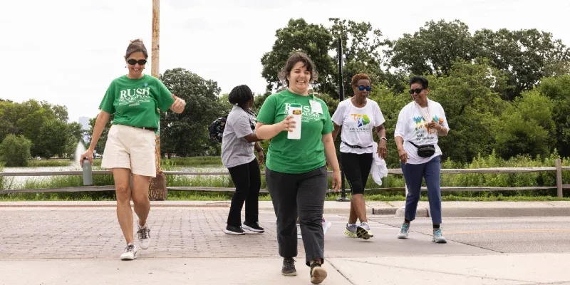 A group of smiling people walking across a road
