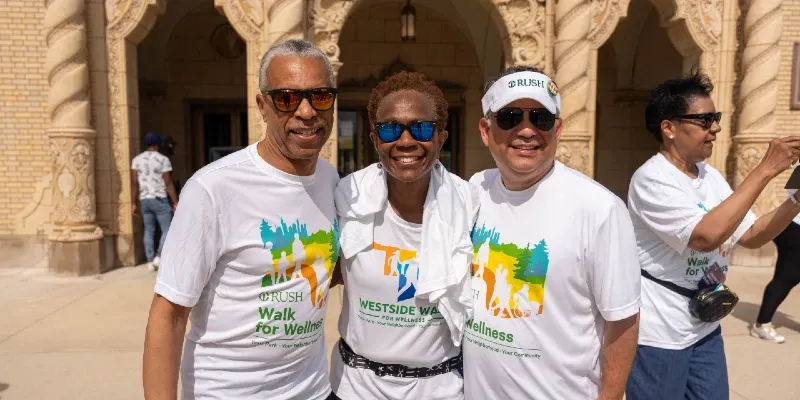 Three people wearing sunglasses and Walk for Wellness t-shirts